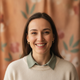 Headshot of a smiling woman in her 30s with a warm, friendly expression and soft, natural lighting.